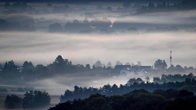 Kabut menyelimuti ladang dan kota Wehrheim dekat Frankfurt, Jerman, 19 Agustus 2020. (AP Photo / Michael Probst)