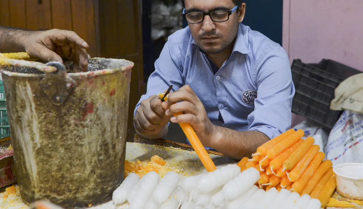 Pekerja tunanetra membuat lilin di bengkel Blind School Relief Association, New Delhi, India, Rabu (16/10/2019). Perkumpulan tersebut menjual lilin, lampu minyak, dan produk kertas yang dibuat oleh para pekerja tunanetra jelang Festival Diwali atau Festival Cahaya. (Sajjad HUSSAIN/AFP)