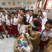 Siswa SD menunggu giliran untuk disuntik difteri di sebuah sekolah dasar di Tangerang,  Senin (11/12). Indonesia memulai sebuah kampanye untuk mengimunisasi 8 juta anak-anak dan remaja dari difteri. (AP Photo / Tatan Syuflana)