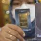 Petugas memperihatkan emas batangan yang dijual di Galeri 24 Pegadaian, Jakarta, Jumat (25/3/2022). Harga emas Antam di Pegadaian kembali naik. Hari ini harga emas Antam naik Rp 6.000 menjadi Rp 1 juta per gram, pada 25 Maret 2022. (Liputan6.com/Angga Yuniar)