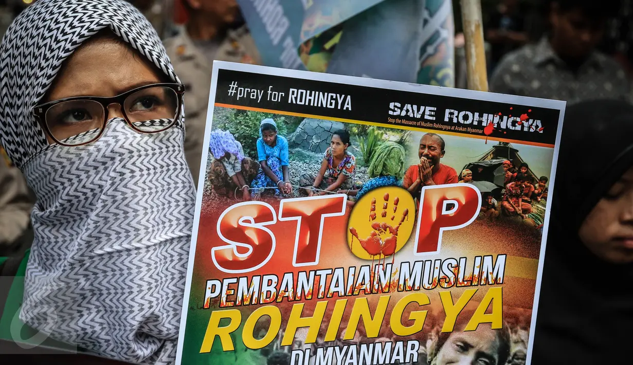 Massa yang mengatasnamakan Solidaritas Muslim Rohingya (SMR) membawa sebuah poster di depan Kedubes Myanmar, Jakarta, Jumat (25/11). Mereka menuntut pemerintah Myanmar segera menghentikan kekerasan terhadap muslim Rohingya. (Liputan6.com/Faizal Fanani)