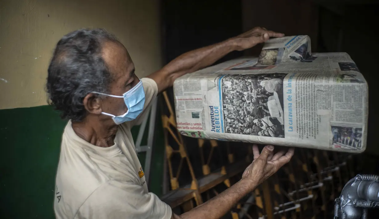 Adolfo Rivera menunjukkan cetakan koran untuk membuat tangki bahan bakar fiberglass pesawat kayunya di garasi gedung apartemennya di Havana, Kuba, 19 Februari 2021. Rivera memperkirakan pesawatnya hingga saat ini telah menelan biaya sekitar 6.600 dolar AS atau RP 93 juta. (AP Photo/Ramon Espinosa)