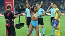 Seorang wanita dari aktivis Femen bertelanjang dada berpose didalam lapangan sebelum pertandingan sepak bola kualifikasi Piala Dunia 2018 antara Ukraina dan Turki di Kharkiv (2/9). (AFP Photo/Sergei Supinsky)