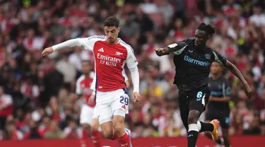 Gelandang Arsenal Kai Havertz berebut bola dengan bek Bayer Leverkusen Odilon Kossounou dalam duel pramusim 2024 di Emirates Stadium, Kamis (8/8/2024) dini hari WIB. (Adam Davy/PA via AP)