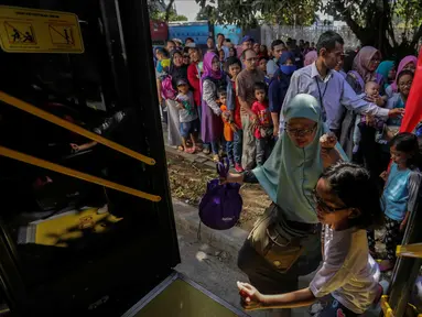 Warga menaiki bus City Tour di kawasan Masjid Istiqlal, Jakarta, Senin (25/12). Libur panjang natal membuat animo warga menggunakan bus City Tour naik drastis. (Liputan6.com/Faizal Fanani)