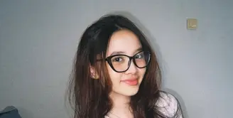 Sybil sering menggerai rambut panjangnya di setiap kesempatan. Dengan gaya messy ia pun menggerai rambutnya sambil mengenakan kaos putih dan kacamatanya.  [@kana.sybilla]