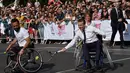 Ekspresi Presiden Prancis Emmanuel Macron saat bermain tenis di atas kursi roda di Paris, Prancis (24/6). Kegiatan ini sebagai bentuk promosi Paris untuk menjadi kandidat tuan rumah Olimpiade dan Paralimpiade 2024. (AFP Photo/Alain Jocard)
