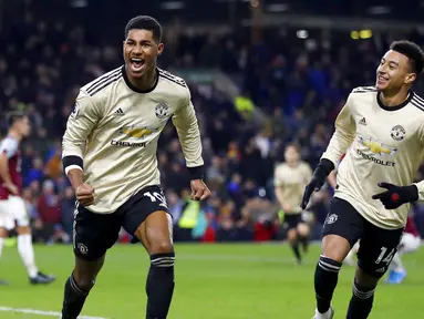 Penyerang Manchester United, Marcus Rashford, melakukan selebrasi usai membobol gawang Burnley pada laga Premier League di Stadion Turf Moor, Sabtu (28/12). Burnley takluk 0-2 dari Manchester United. (AP/Martin Rickett)