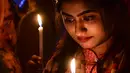 Wanita Bangladesh memegang lilin untuk memperingati Hari Perempuan Internasional di Dhaka (7/3). Hari Perempuan Internasional jatuh pada tanggal 8 Maret setiap tahunnya. (AFP Photo/Munir Uzzaman)