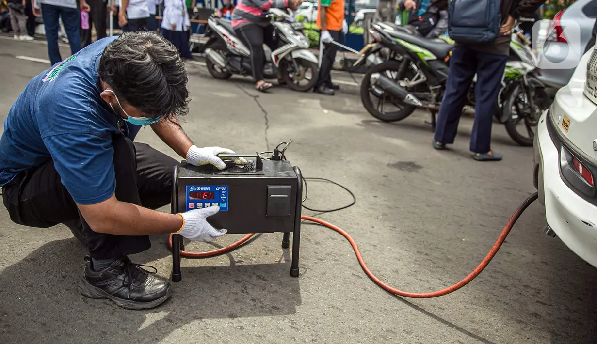 Petugas mengecek emisi gas buang kendaraan bermotor di Jakarta, Rabu (6/1/2021). Pengecekan yang diselenggarakan Dinas Perhubungan dan Kepolisian tersebut bertujuan untuk mengurangi polusi udara dari emisi gas buang kotor. (Liputan6.com/Faizal Fanani)