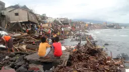 Warga berada diluar rumah pasca terkena Topan Melor di desa Pigcale, Legazpi, provinsi Albay, Filipina (15/12). Dasyat Topan Melor menyebabkan banjir, badai 800.000 orang dievakuasi dari Filipina tengah. (REUTERS/Rhaydz Barcia)