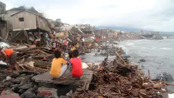 Warga berada diluar rumah pasca terkena Topan Melor di desa Pigcale, Legazpi, provinsi Albay, Filipina (15/12). Dasyat Topan Melor menyebabkan banjir, badai 800.000 orang dievakuasi dari Filipina tengah. (REUTERS/Rhaydz Barcia)