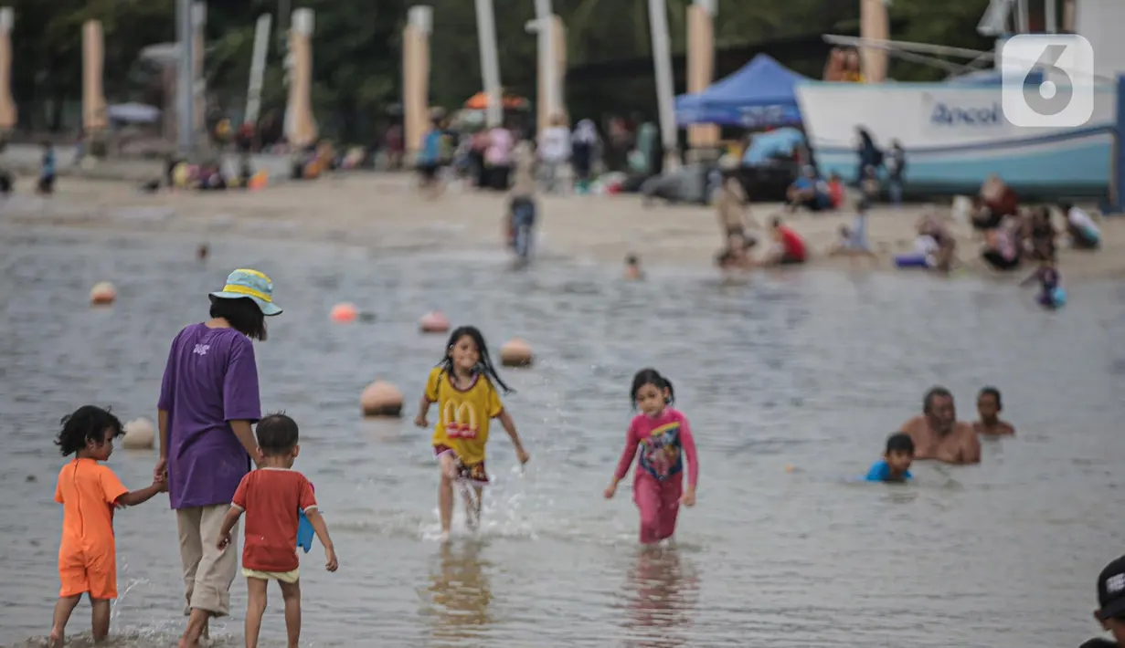 Pengujung berwisata di Pantai Ancol, Jakarta, Rabu (28/12/2022). Isu cuaca yang kurang bersahabat pada hari ini, tidak menyurutkan keinginan warga menghabiskan libur untuk berwisata di kawasan wisata Ancol. (Liputan6.com/Faizal Fanani)