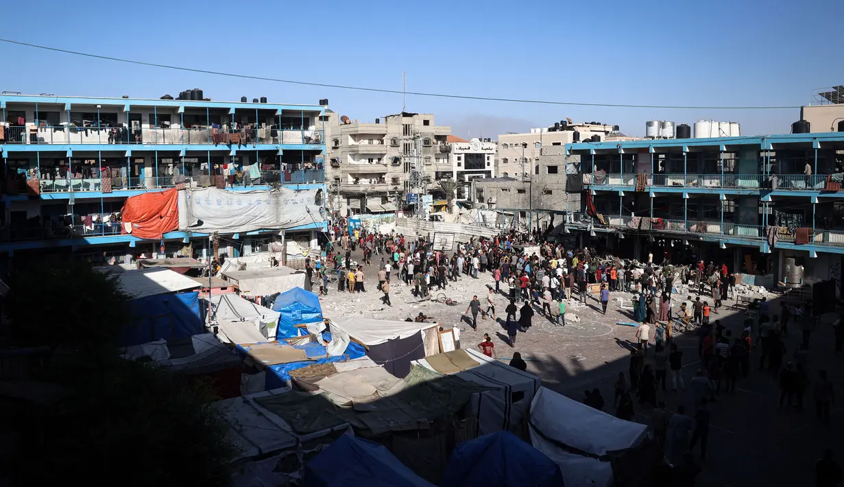 Warga Palestina berdiri di halaman sekolah Al-Jawni (Jaouni) setelah serangan udara Israel menghantam lokasi tersebut, di Nuseirat, Jalur Gaza tengah pada 11 September 2024. (Eyad BABA/AFP)