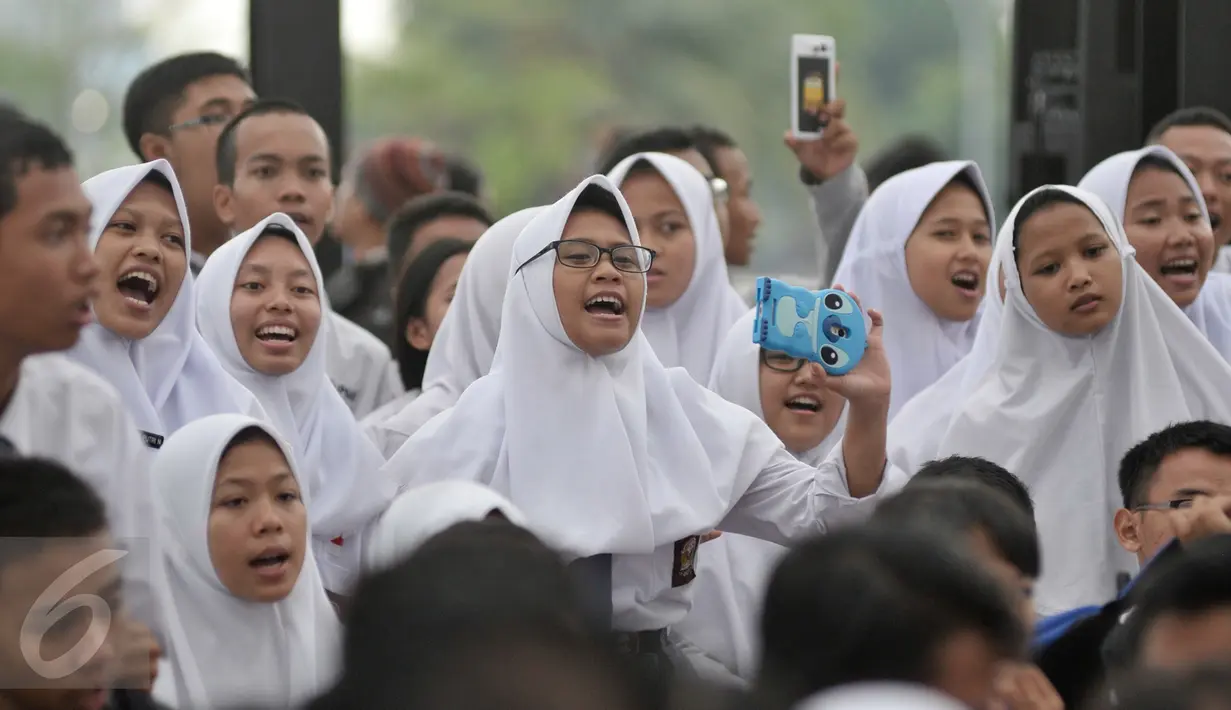 Ekspresi sejumlah pelajar saat menikmati penampilan dari penyanyi Tulus dalam acara Pesta Pendidikan di RPTRA Kalijodo, Jakarta, Selasa (2/5). (Liputan6.com/Yoppy Renato)