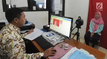 Petugas melakukan proses perekaman data pembuatan e-KTP di Kantor kelurahan Cinere, Depok, Kamis (27/12). Hari ini Disdukcapil daerah melaksanakan pelayanan jemput bola perekaman E-KTP serentak khusus pemula secara nasional. (Merdeka.com/Arie Basuki)