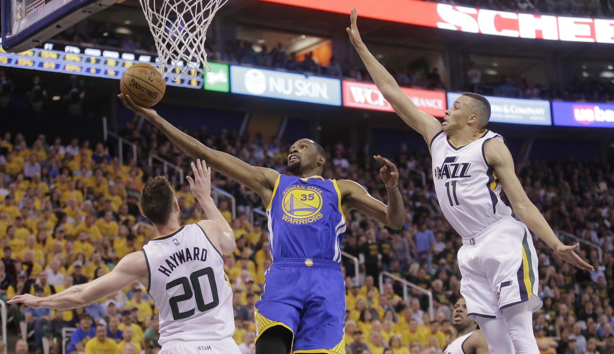 Aksi forward Golden State Warriors, Kevin Durant  (tengah) melakukan lay up melewati adangan para pemain Utah Jazz pada gim keempat playoff NBA di Salt Lake City, Senin (8/5/2017). Warriors menang 121-95.  (AP/Rick Bowmer)
