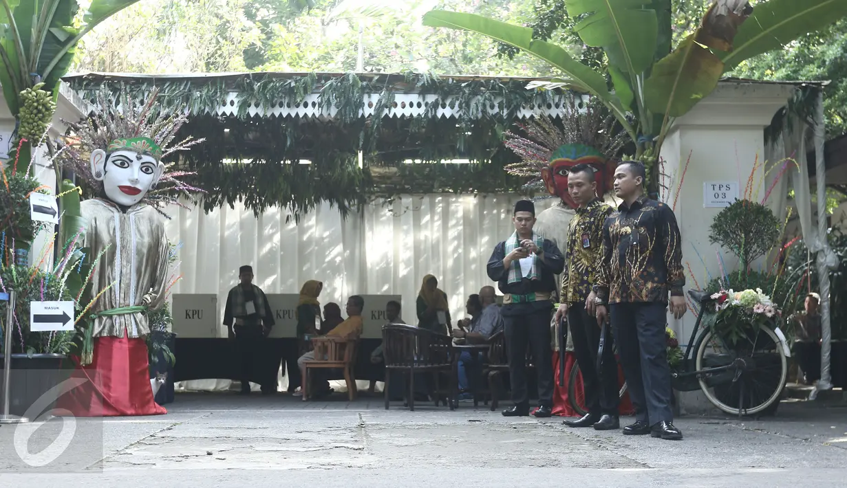 Petugas KPPS berbusana khas betawi menunggu warga yang akan menggunakan hak pilihnya pada pilkada DKI 2017 di TPS 03, Kelurahan Pulo, Jakarta Selatan, Rabu (19/4). Di TPS ini Wapres JusUf Kalla akan menyalurkan hak pilihnya. (Liputan6.com/Herman Zakharia)