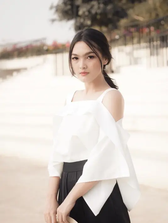 Baju dengan model off shoulder putih yang dipadukan rok plisket hitam adalah perpaduan sempurna. Penampilan monochrome gadis berwajah manis ini terlihat stylish dan modis. (Liputan6.com/IG/@anariana27)
