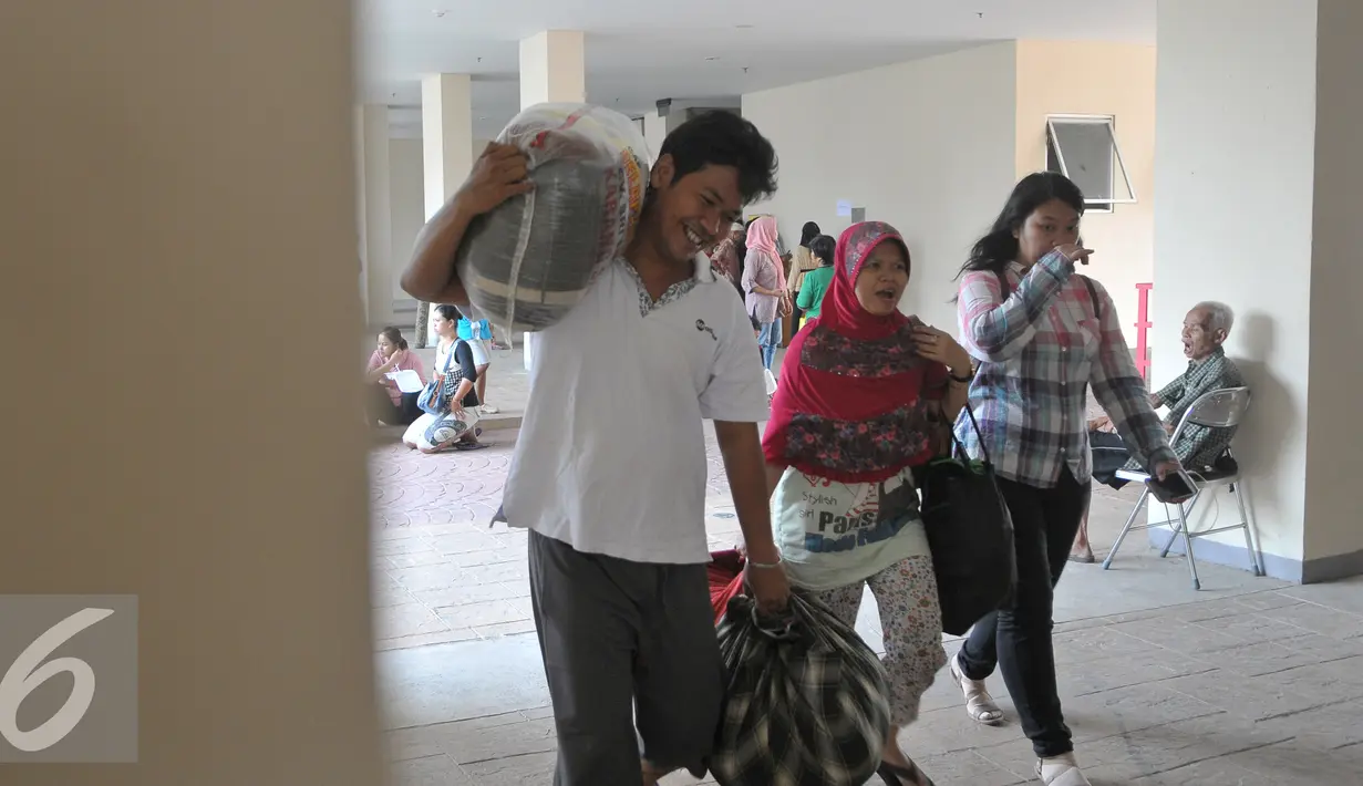 Suasana kedatangan para penghuni dari Kampung Pulo ke Rusunawa Jatinegara Barat, Jakarta, Jumat (21/8/2015). Dari 429 warga yang telah mengikuti undian unit hunian, baru 238 warga Kampung Pulo yang telah mengambil kunci. (Liputan6.com/Herman Zakharia)