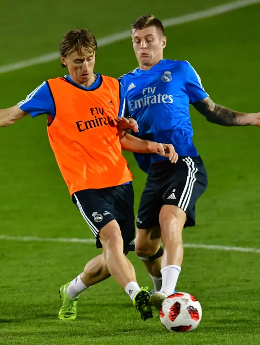 Gelandang Real Madrid, Luca Modric berebut bola dengan Toni Kroos saat latihan jelang menghadapi Kashima Antlers pada semifinal Piala Dunia Antarklub 2018 di stadion New York University Abu Dhabi, Uni Emirat Arab (17/12). (AFP Photo/Giuseppe Cacace)