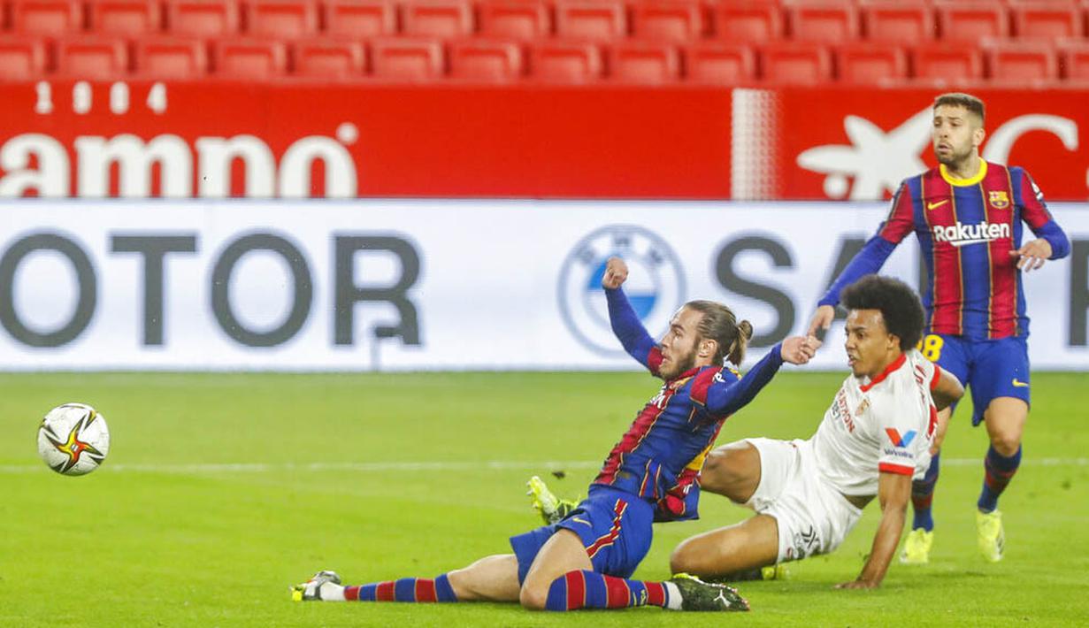 Pemain Sevilla, Jules Kounde, mencetak gol ke gawang Barcelona pada laga leg pertama semifinal Copa del Rey di Estadio Ramon Sanchez Pizjuan, Kamis (11/2/2021). Barcelona tumbang dengan skor 2-0. (AP/Angel Fernandez)