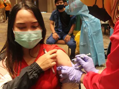 Seorang wanita mengikuti vaksinasi gelombang II pelaksanaan vaksinasi Covid-19 di Ballroom Novotel Tangerang, pada Senin,(1/3/2021). Pelaksanaan vaksinasi Covid-19 tersebut digelar Dinas Kesehatan Kota Tangerang. (merdeka.com/Arie Basuki)