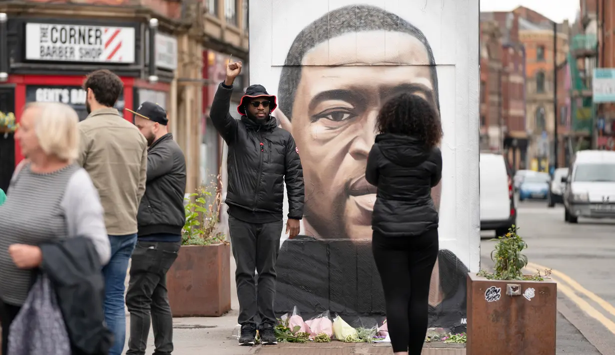 Warga berpose bersama mural George Floyd di Manchester tengah, Inggris (4/6/2020). George Floyd tewas kehabisan napas saat dalam penahanan pihak kepolisian Negara Bagian Minnesota, wilayah Midwest Amerika Serikat, pada pekan lalu. (Xinhua/Jon Super)