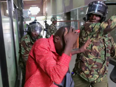 Polisi memukuli seorang demonstran di dalam sebuah gedung saat bentrokan di Nairobi, Kenya (16/5). Demonstran menuntut pembubaran otoritas pemilu karena adanya dugaan korupsi. (REUTERS/Goran (REUTERS/Goran Tomasevic)