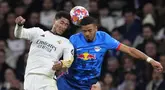Pemain Real Madrid, Jude Bellingham (kiri) berduel udara dengan pemain RB Leipzig, Benjamin Henrichs pada laga leg kedua 16 besar Liga Champions 2023/2024 di Santiago Bernabeu, Madrid, Spanyol, Kamis (07/03/2024) WIB. (AP Photo/Manu Fernandez)