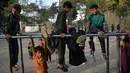 Anak-anak bermain pada palang besi yang terpasang di Shahr-e Naw Park, Kabul, Afghanistan, 9 September 2021. Taliban menguasai Afghanistan setelah pasukan Amerika Serikat meninggalkan negara tersebut. (HOSHANG HASHIMI/AFP)