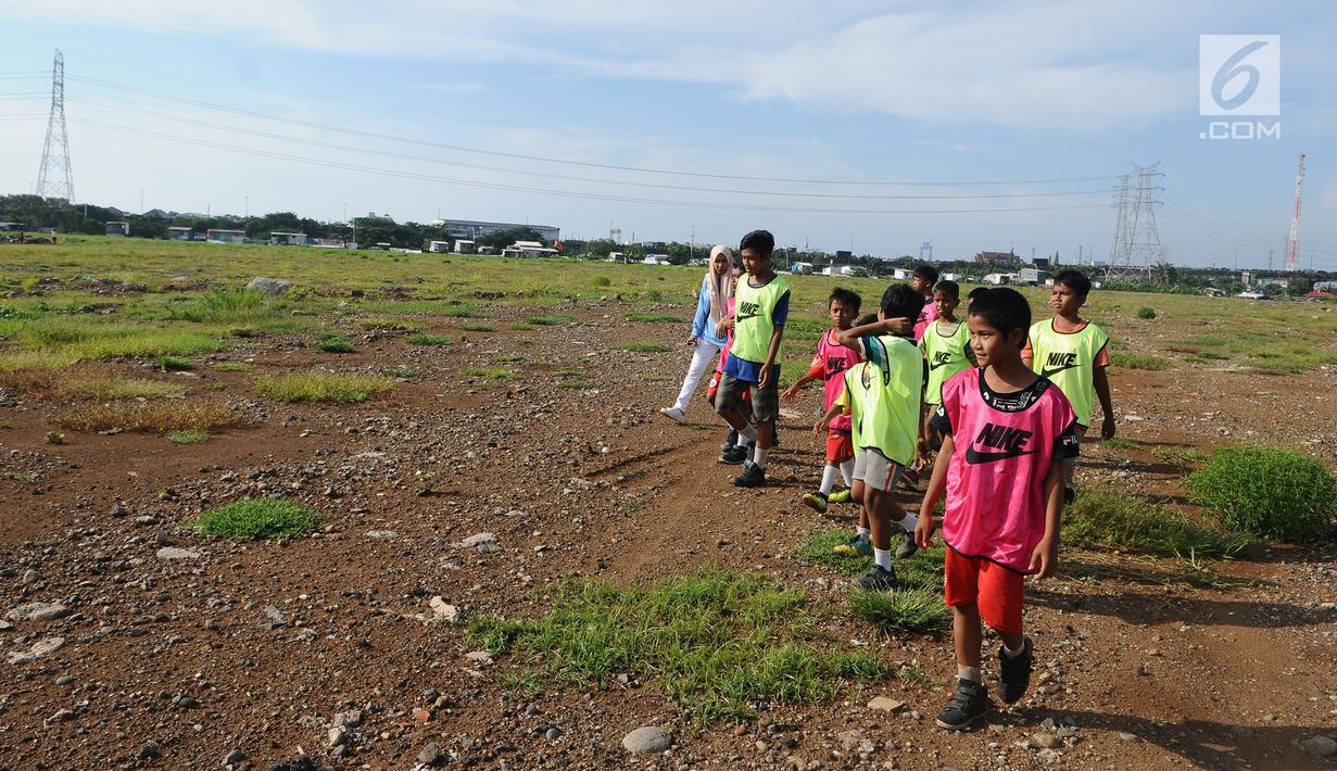 Sejumlah anak melintas dilahan Jakarta International Stadium di Jakarta, Kamis (14/3). Jakarta International Stadium ditargetkan akan selesai pada tahun 2021 mendatang dengan kapasitas sekitar 82.000 orang.