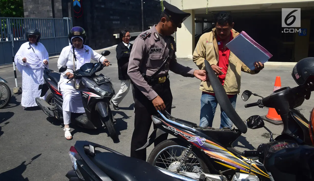 Anggota polisi menggeledah motor tamu pengunjung yang datang ke Mapolda Jawa Tengah, Kota Semarang, Senin (14/5).Tak ingin kecolongan, Mapolda Jateng memperketat pengamanan menyusul aksi teror bom yang bertubi-tubi. (Liputan6.com/Gholib)