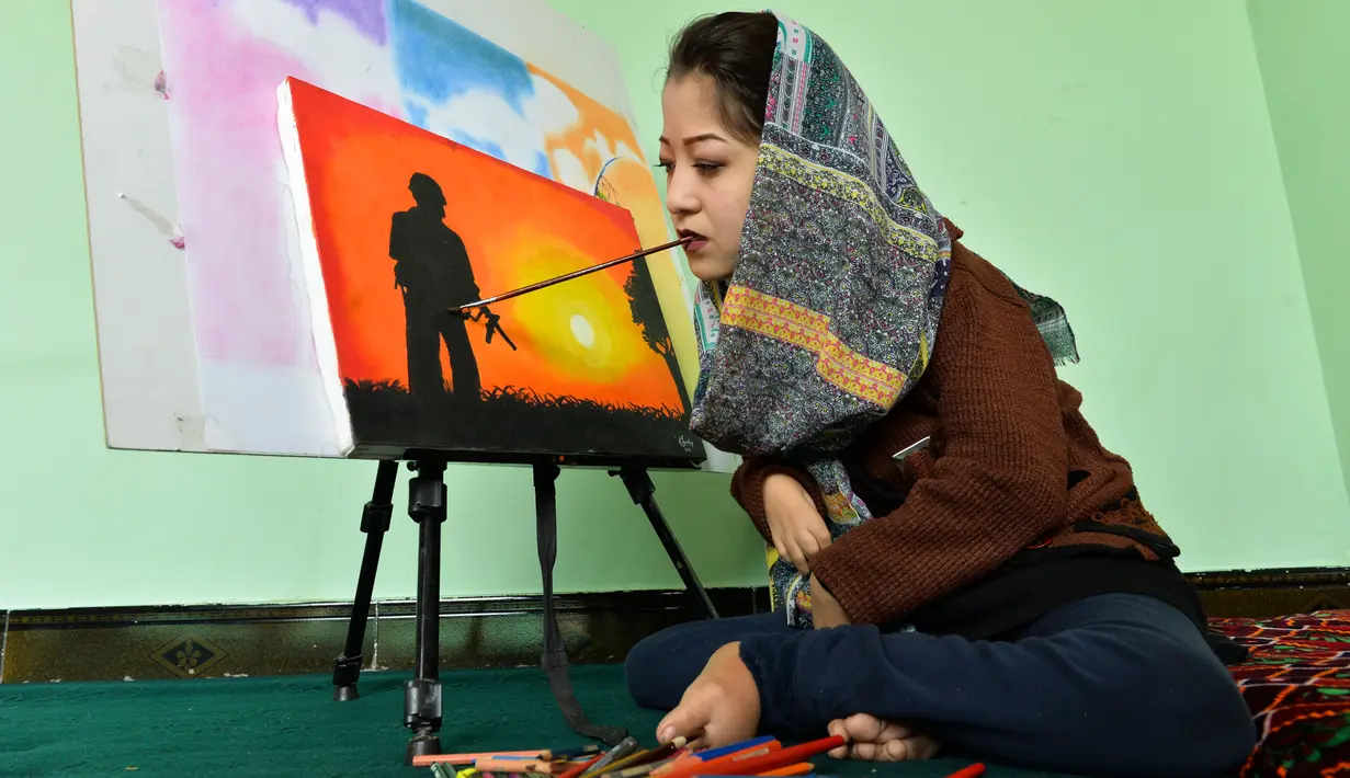 Foto yang diambil pada 5 Desember 2019 menunjukkan seniman Robaba Mohammadi melukis menggunakan mulut di studionya di Kabul. Gadis 19 tahun itu dilahirkan  dengan kelumpuhan parsial anggota tubuhnya sehingga tidak mampu mengendalikan tangan dan kakinya. (NOORULLAH SHIRZADA/AFP)