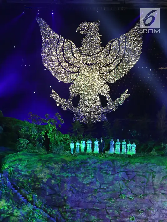 Penyanyi Tulus memimpin penonton menyanyikan lagu "Indonesia Raya" saat pengibaran bendera Merah Putih dalam pembukaan Asian Games 2018 di Stadion Utama Gelora Bung Karno (SUGBK), Jakarta, Sabtu (18/8). (Liputan.com/Fery Pradolo)