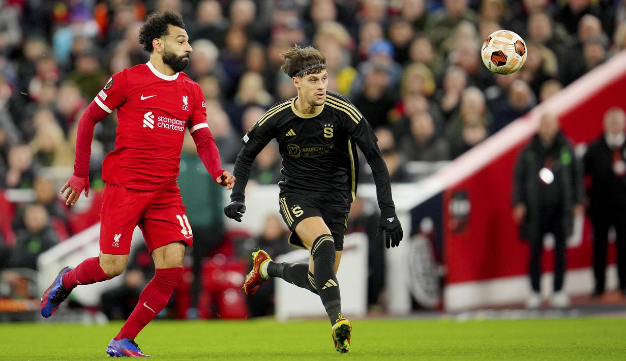 Pemain Liverpool, Mohamed Salah (kiri) berebut bola dengan pemain Sparta Praha,Veljko Birmancevic pada laga leg kedua 16 besar Liga Europa 2023/2024 di Anfield, Liverpool, Inggris, Jumat (15/03/2024). (AP Photo/Jon Super)