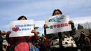 Anggota keluarga penumpang pesawat Malaysia Airlines MH370 berunjuk rasa membawa poster di Lama Temple, Beijing, Cina, (8/3). Poster Tersebut bertuliskan "Ibu akan selalu menunggu. Tidak akan menyerah." (REUTERS/Kim Kyung-hoon)