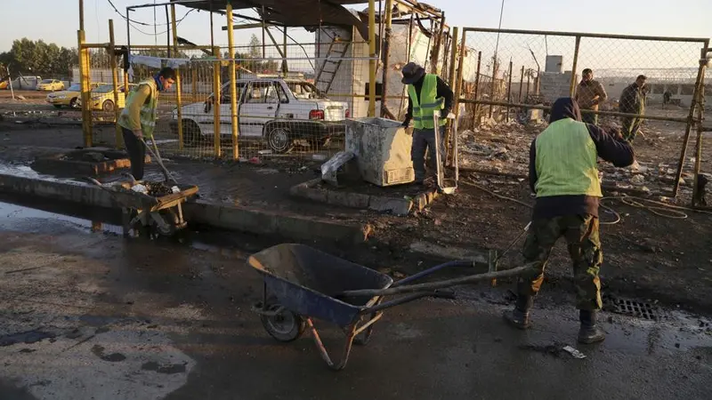 Petugas tengah membersihkan sisa ledakan bom mobil di Bayaa, Baghdad, Irak. (AP)