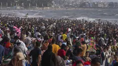 Warga memadati pantai Juhu di Laut Arab pada hari yang panas dan lembab di kota Mumbai, India, 8 Mei 2022. Musim panas yang terik di India menambah risiko baru tahun ini. Suhu di India melebihi 40 derajat Celcius di banyak daerah. (AP Photo/Rafiq Maqbool)