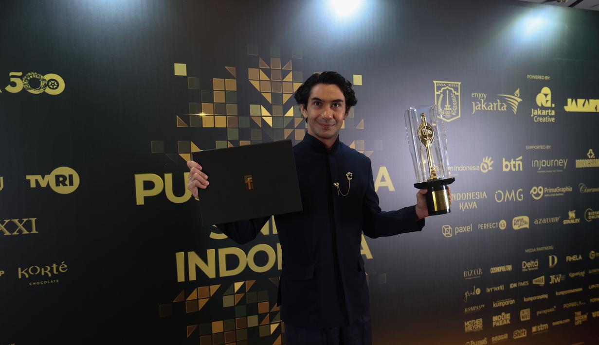 Reza Rahadian berfoto bersama Piala Citra FFI pada malam penganugerahan di Taman Ismail Marzuki (TIM) Jakarta pada Kamis (20/11/2025) malam. Film ‘Pangku’ karyanya berhasil meraih Piala Citra kategori Film Cerita Panjang Terbaik atau Film Terbaik. (Kapanlagi.com/Budy Santoso)