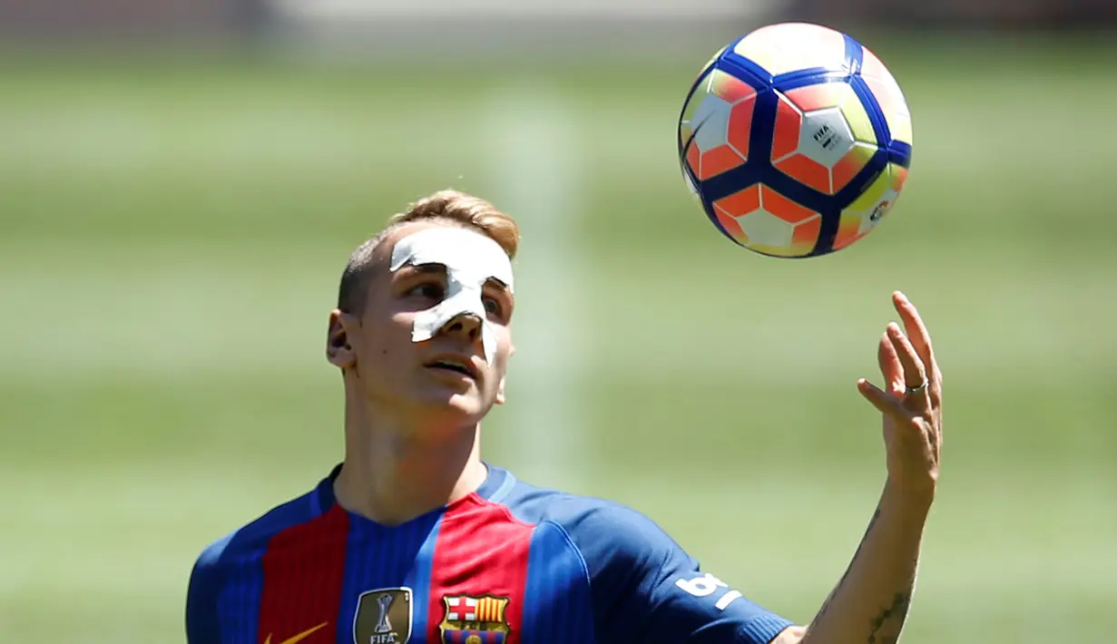 Pemain baru FC Barcelona, Lucas Digne bola saat diperkenalkan di stadion Camp Nou, Barcelona , Spanyol , (14/7). Pemain PSG yang terakhir dipinjamkam AS Roma ini akan menjadi pesaing serius Bek Barcelona Jordi Alba. (REUTERS / Albert Gea)