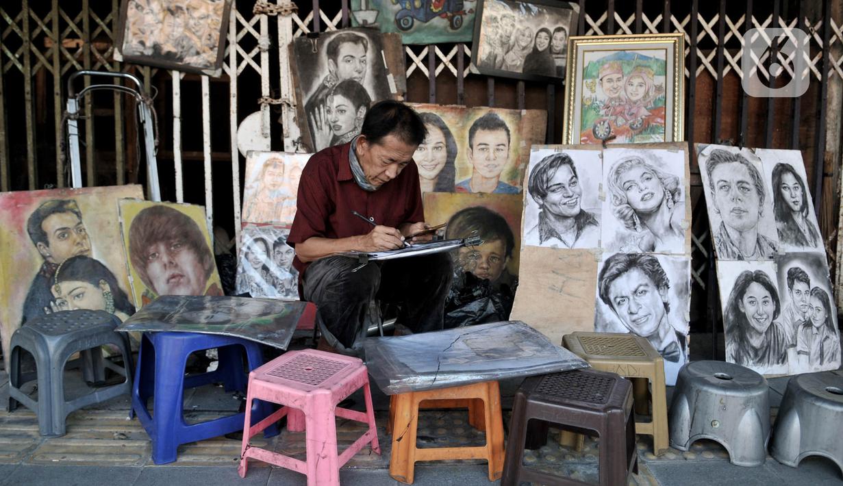 Seniman lukis menyelesaikan karyanya di pinggir Jalan Pintu Besar Selatan, Pinangsia, Jakarta, Selasa (2/6/2020). Sejumlah seniman memilih tutup sementara di tengah pandemi virus corona COVID-19, sedangkan beberapa lainnya tetap bertahan demi mendapatkan penghasilan. (merdeka.com/Iqbal S. Nugroho)