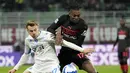 Penyerang AC Milan Rafael Leao berebut bola dengan gelandang Empoli Szymon Zurkowski pada pekan ke-29 Liga Italia di Stadion San Siro, Minggu (13/3/2022) dini hari WIB.  AC Milan menang tipis 1-0 atas tamunya, Empoli. (AP Photo/Antonio Calanni)