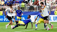 Gelandang Jerman Felix Nmecha (kiri) dilanggar bek Curacao Riechedly Bazoer pada laga Grup E Piala Dunia 2026.. (AFP/Molly Darlington)