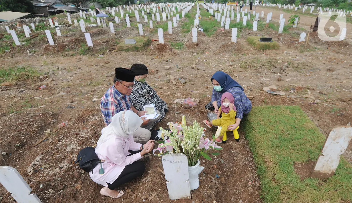 Warga berdoa di depan pusara keluarganya saat ziarah kubur di TPU Srengseng Sawah 2, Jagakarsa, Jakarta Selatan, Senin (17/5/2021). Hari ini seluruh TPU di wilayah DKI dibuka untuk umum dengan menerapkan protokol kesehatan seperti pembatasan pengunjung dan waktu berziarah. (merdeka.com/Arie Basuki)
