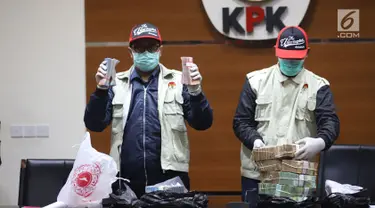 Petugas KPK menunjukkan barang bukti uang saat jumpa pers terkait OTT Bupati Cirebon Sunjaya Purwadi Sastra di Gedung KPK, Jakarta, Kamis (25/10). KPK menetapkan Sunjaya sebagai tersangka suap jual beli jabatan. (Liputan6.com/Herman Zakharia)