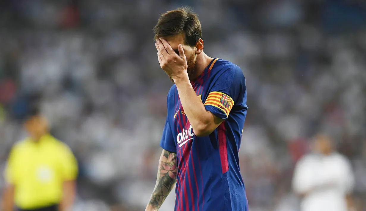 Striker Barcelona, Lionel Messi, menutup mukanya usai takluk dari Real Madrid pada laga Piala Super Spanyol 2017 di Stadion Santiago Bernabeu, Rabu (16/8/2017). Real Madrid menang 2-0 atas Barcelona. (AFP/Gabriel Bouys)