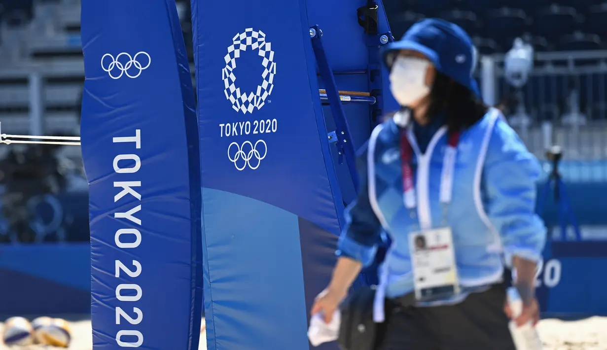 Petugas meninggalkan lapangan voli pantai usai melakukan sanitasi dan pembersihan jelang dimulainya Olimpiade Tokyo 2020 di Shiokaze Park, Tokyo, Jepang, Rabu (21/7/2021). Olimpiade Tokyo 2020 digelar dengan penerapan protokol kesehatan ketat guna mencegah penularan COVID-19. (Angela Weiss/AFP)