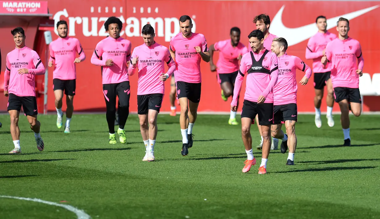 Para pemain Sevilla melakukan pemanasan selama sesi latihan tim di tempat latihan Ciudad Deportiva Jose Ramon Cisneros Palacios,  Spanyol (16/2/2021). Sevilla dan Dortmund Keduanya sama-sama menyandang status tim kuda hitam di Liga Champions. (AFP/Cristina Quicler)