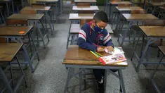 Sebastian (7) mengikuti kelas matematika sendirian pada hari pertama kembali ke sekolah tatap muka sejak dimulainya pembatasan pandemi COVID-19 di Sekolah Andres Bello, Caracas, Venezuela, 25 Oktober 2021. (AP Photo/Ariana Cubillos)